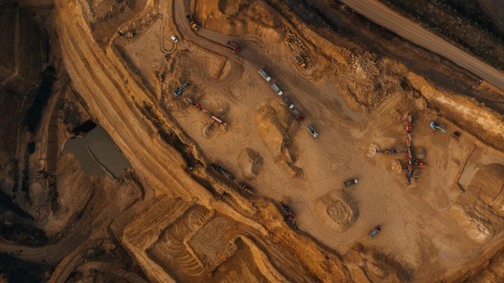Aerial shot of an active mining site in England, showcasing natural deposits and excavation equipment.