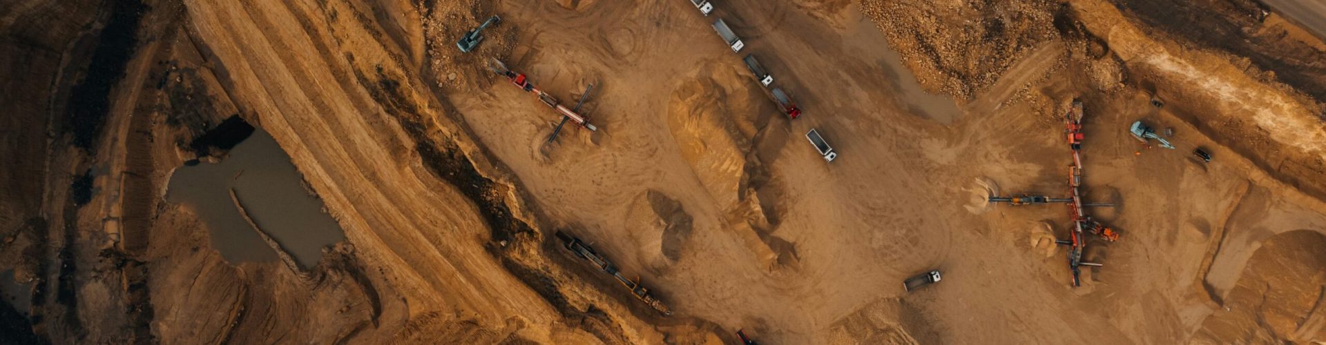Aerial shot of an active mining site in England, showcasing natural deposits and excavation equipment.